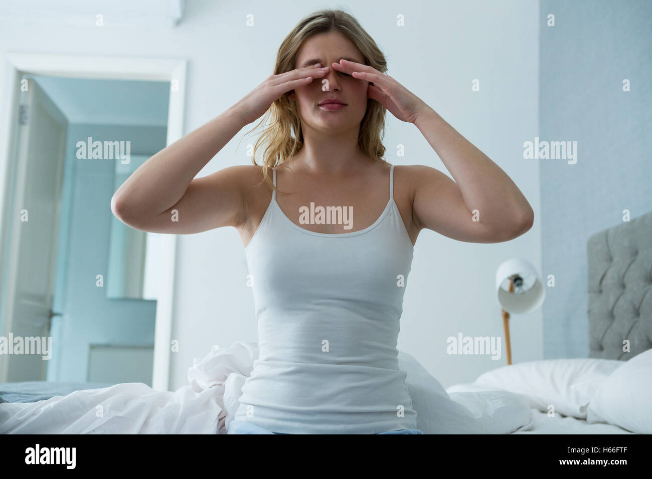 Giovane donna risveglio dal sonno in camera da letto Foto Stock