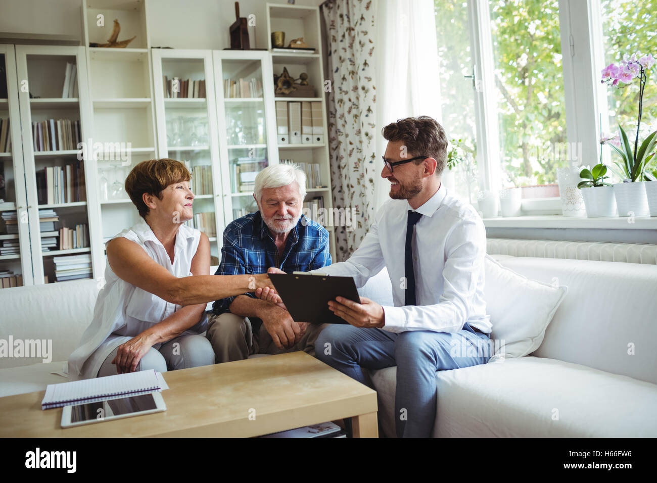 Advisor finanziario stringono le mani con i senior donna Foto Stock