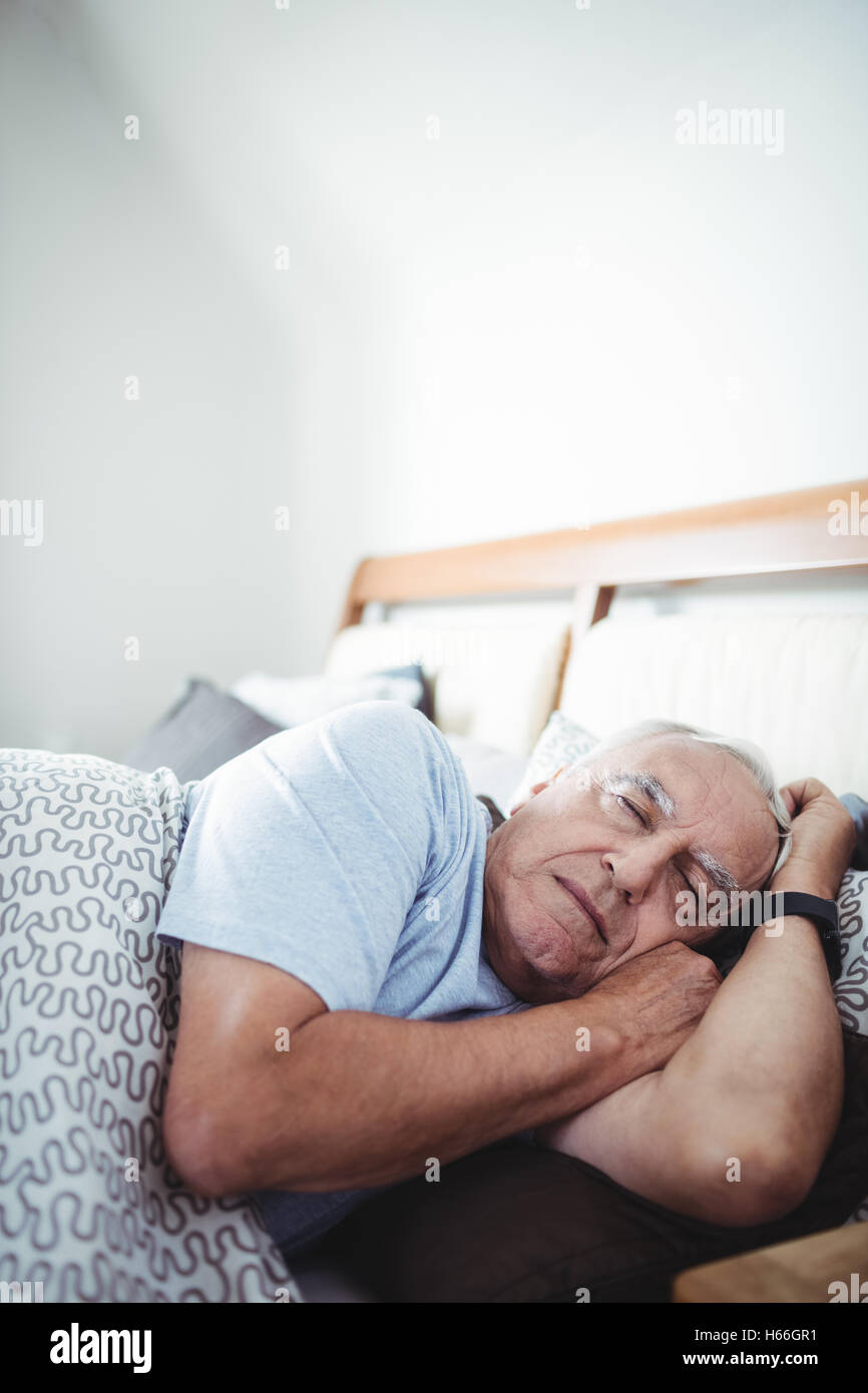 Senior uomo dorme sul letto Foto Stock