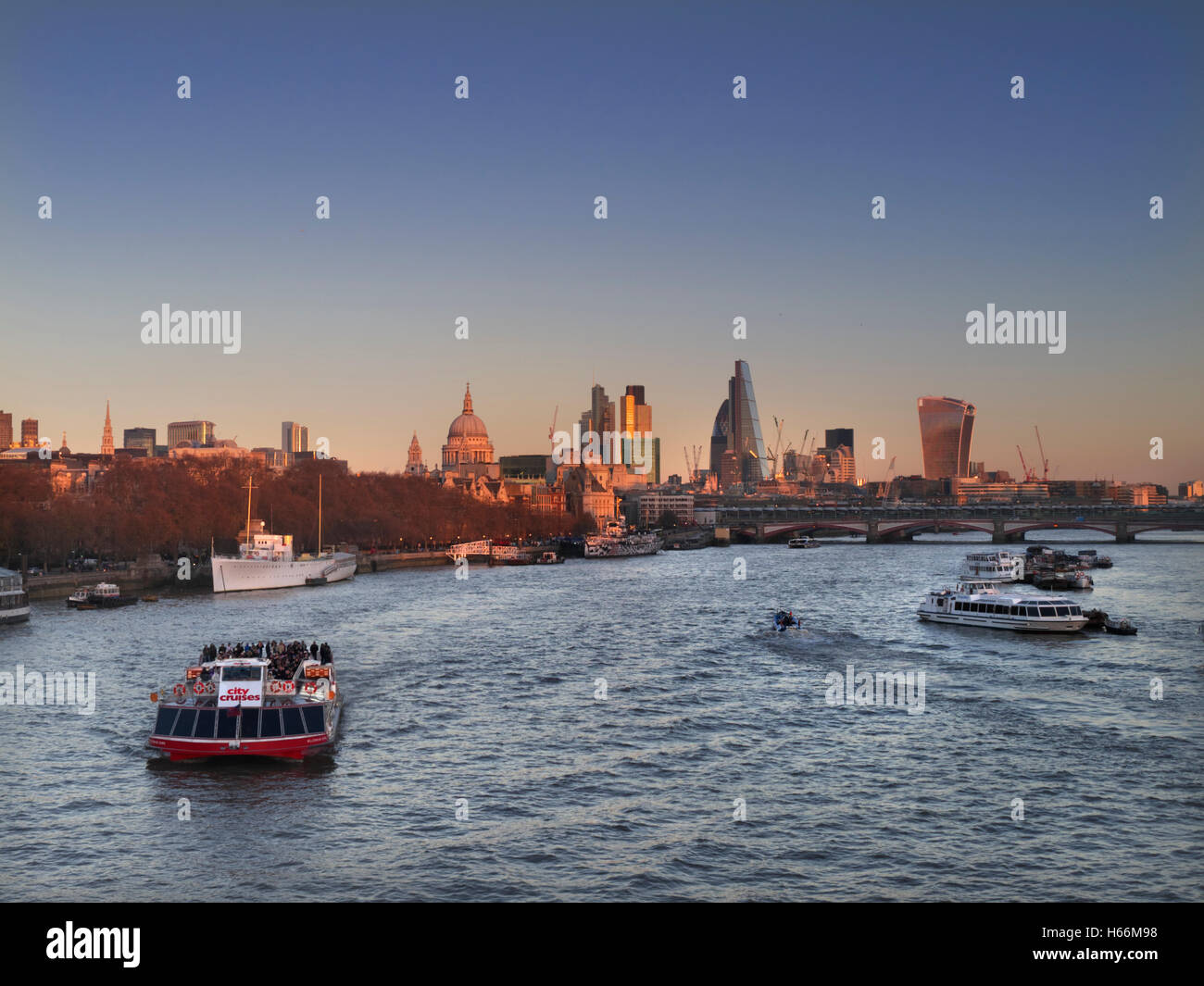 Città di Londra San Paolo e il fiume Tamigi visto da Waterloo Bridge London REGNO UNITO al tramonto con pranzo il piacere di crociera in barca in primo piano Foto Stock