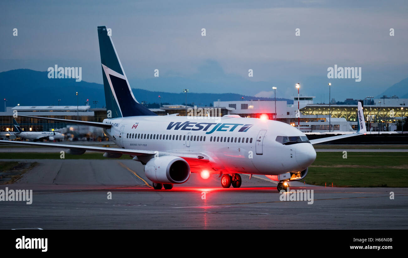 WestJet Airlines Boeing 737 C-FIWJ tarmac South terminal aeroporto Internazionale di Vancouver aeroporto principale in background Foto Stock