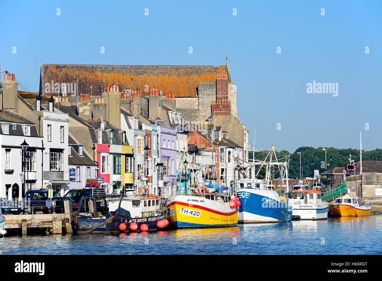 Vista delle barche da pesca e gli edifici di banchina nel porto di Weymouth Dorset, Inghilterra, Regno Unito, Europa occidentale. Foto Stock