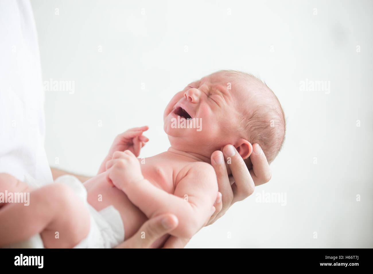 Ritratto di un neonato urlante tenere a portata di mano Foto Stock