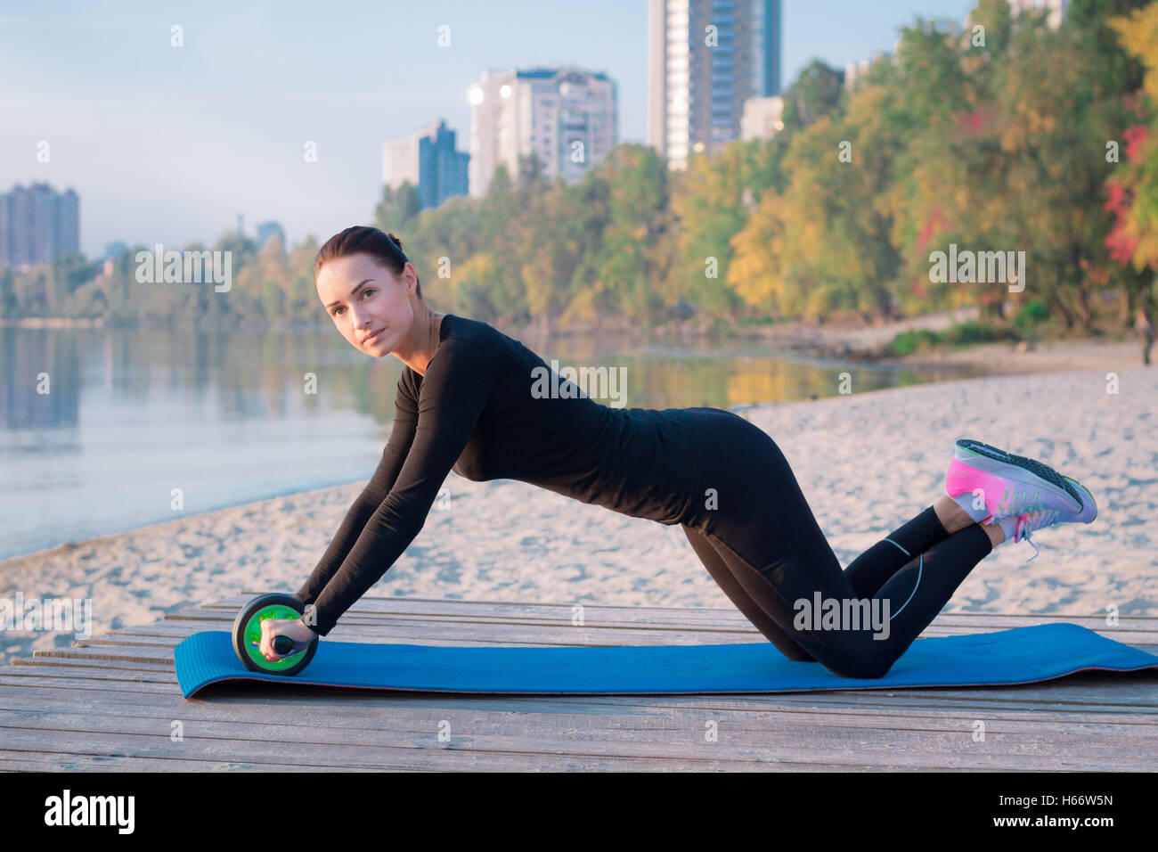 Giovane bella donna fitness esercita sul molo durante la mattina allenamento di formazione Foto Stock