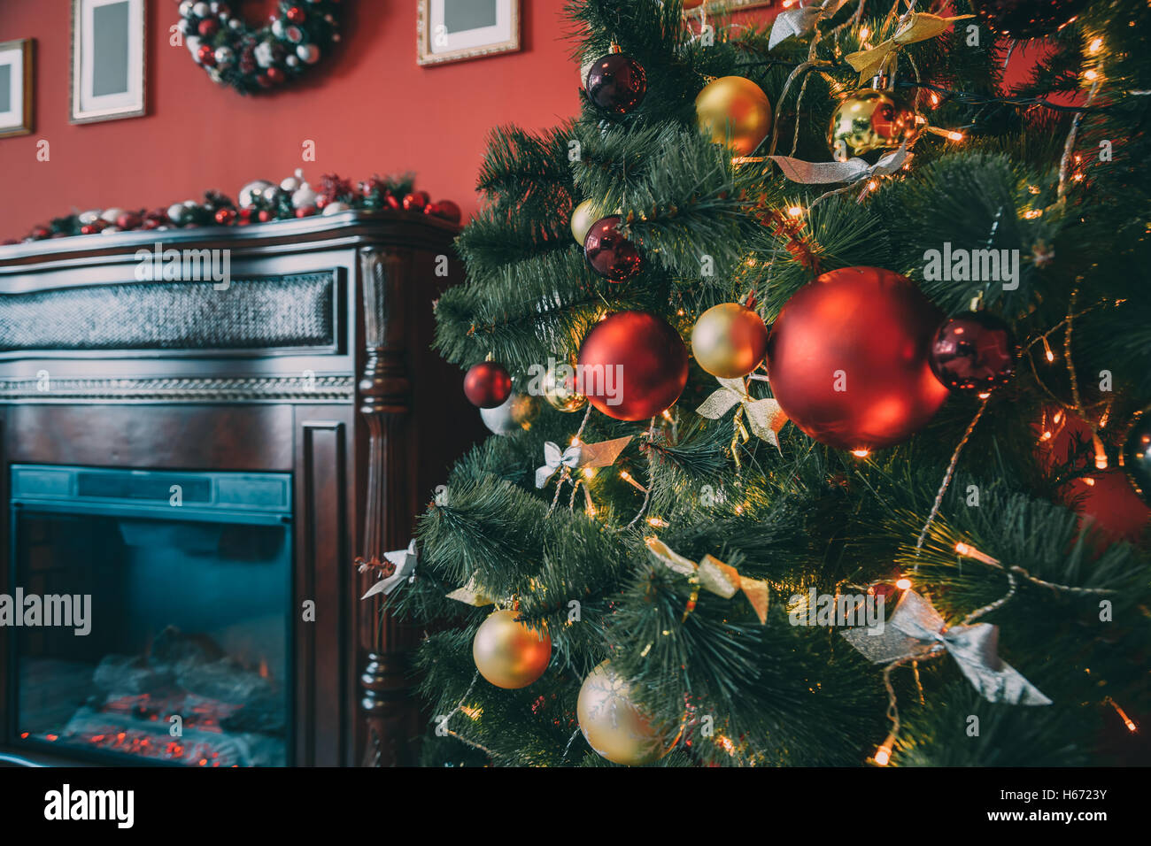 Bellissimo e nuovo anno camera con albero di Natale decorato e camino. L'idea per cartoline. soft focus. shallow dof Foto Stock