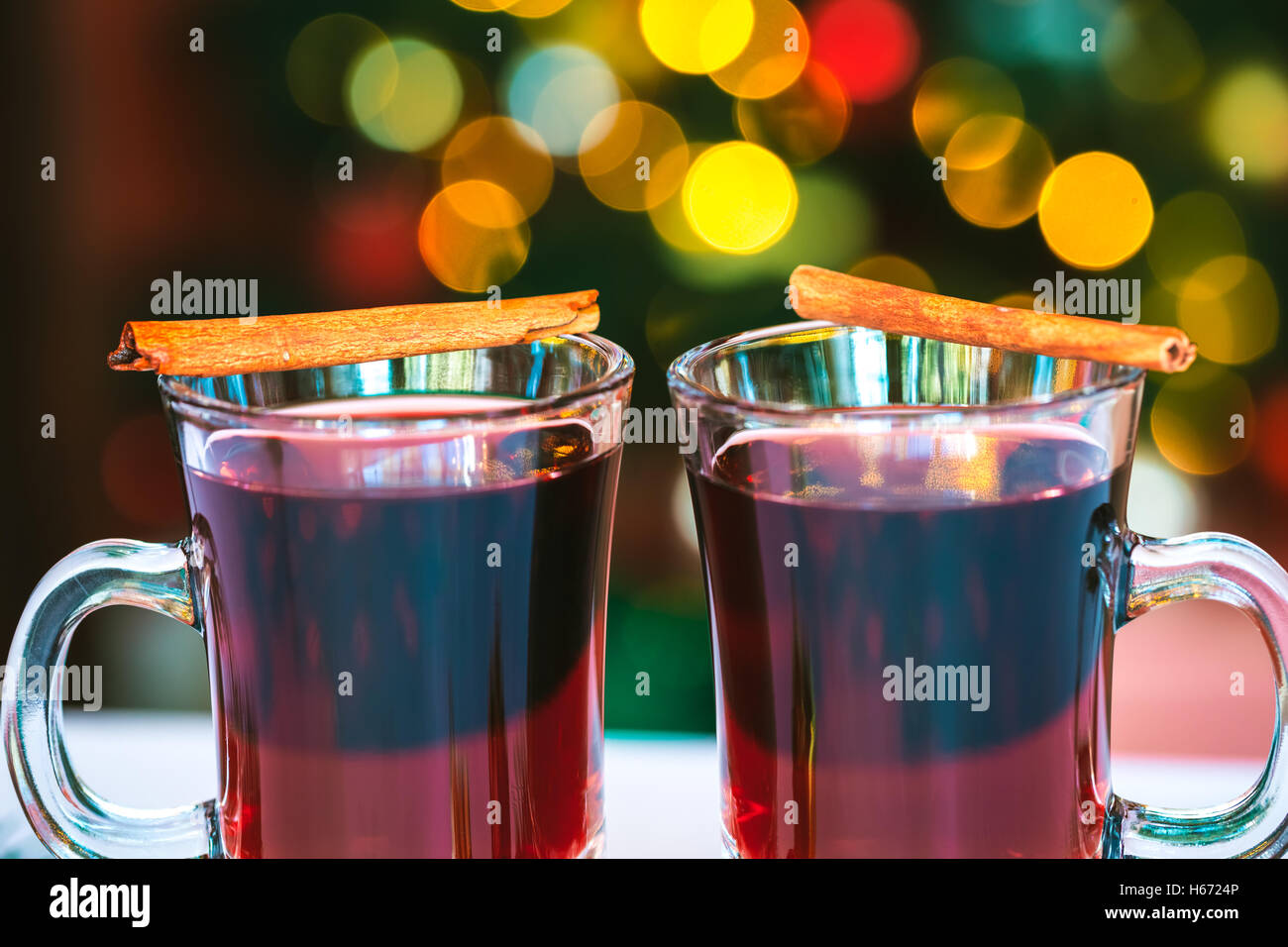 Bella due bicchieri di vino brulé in piedi sullo sfondo di una offuscata albero di Natale decorato. soft focus. shallow dof Foto Stock