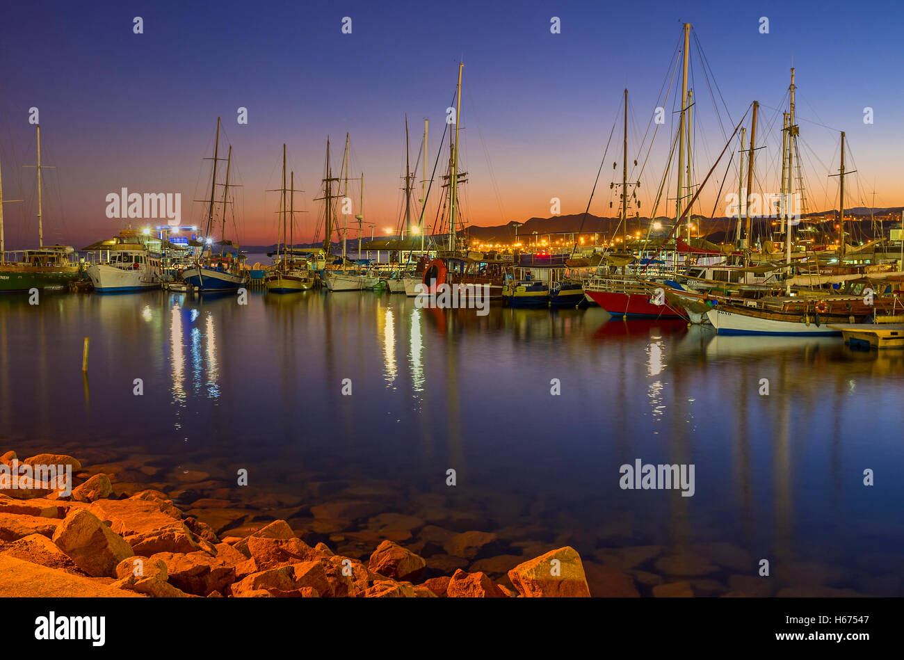 Il bella vista del porto di sera, piena di yacht e barche, con il rosso twilight sky su sfondo, Eilat Foto Stock