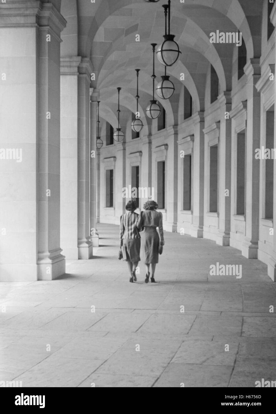 Vista posteriore di due donne a piedi su superfici curve passeggiata che conduce da Benjamin Franklin Post Office, 12th Street vicino a Pennsylvania Avenue a Washington DC, USA, David Myers per ufficio di informazione di guerra, Luglio 1939 Foto Stock