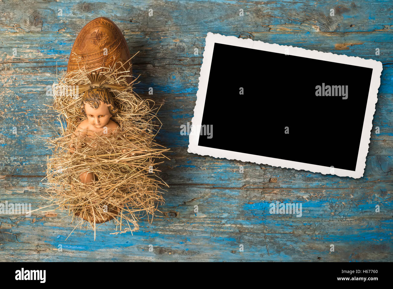 Il tempo di Natale,antica statuetta di Gesù Bambino in agricoltore tradizionale intasare, su sfondo rustico Foto Stock