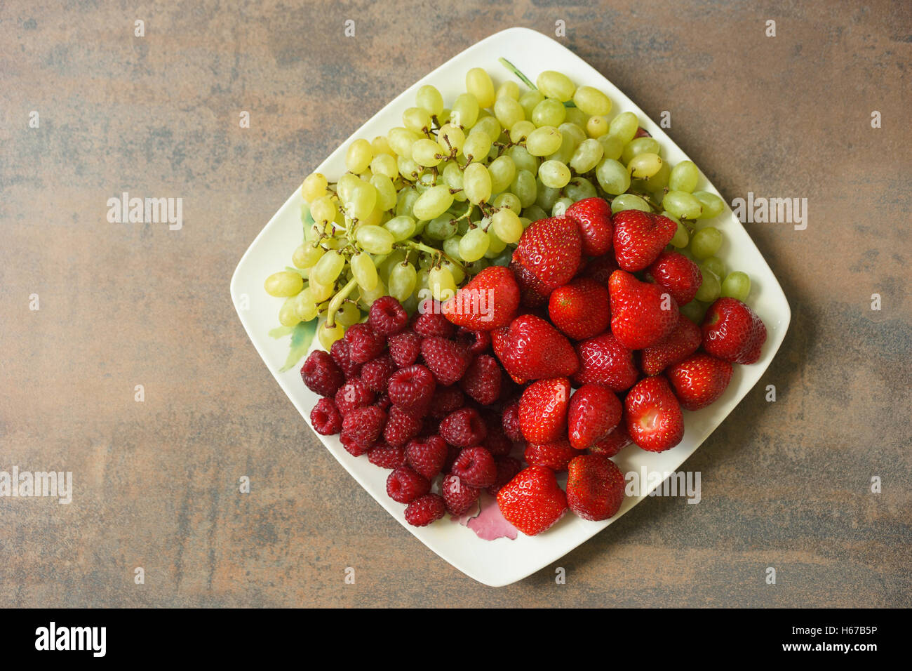 Piastra con miscela di fragole, lamponi e uva, vista dall'alto Foto Stock