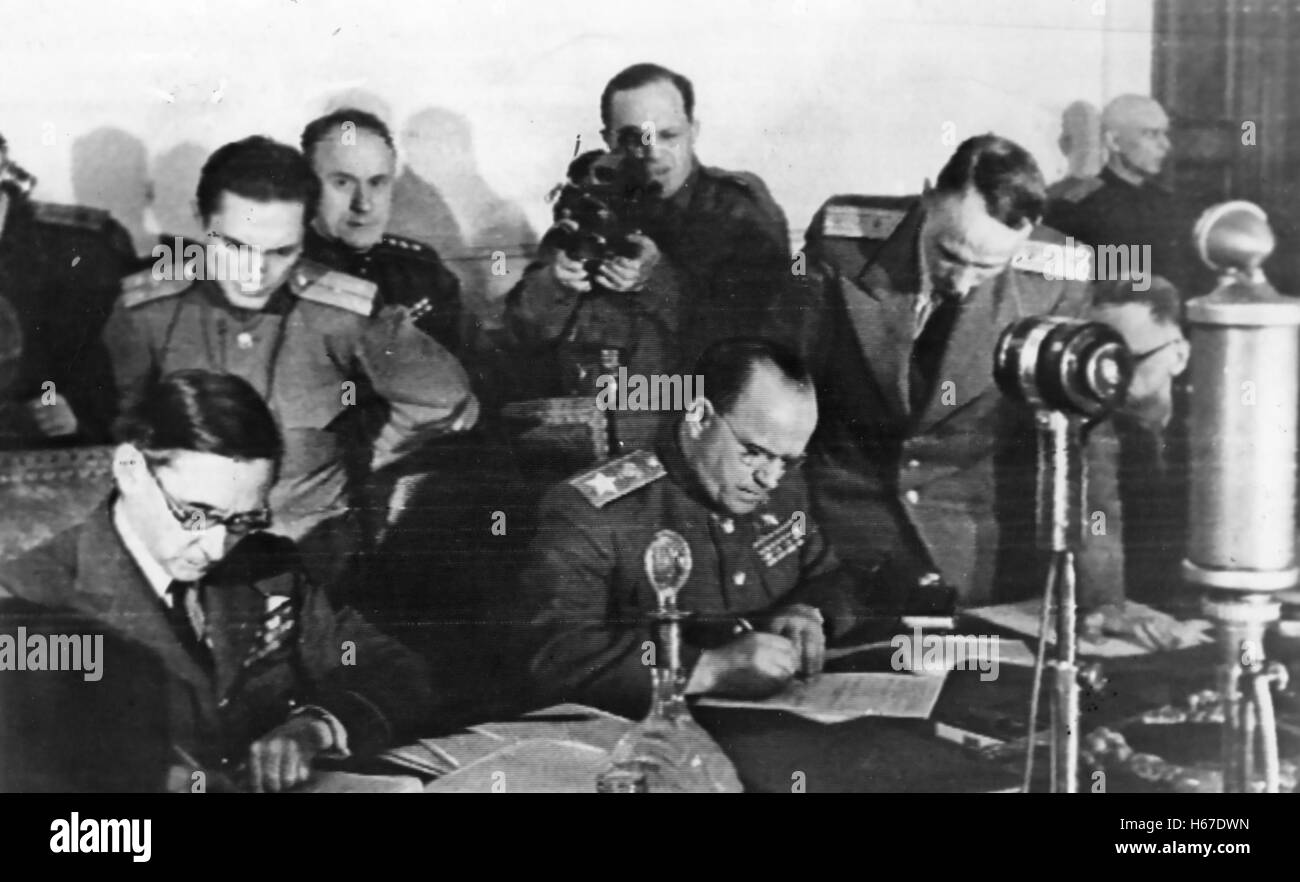 Il tedesco rinuncia Marshall sovietico Georgy Zhukov centro e UK Air Chief Marshall Arthur Tedder a sinistra aggiungi le loro firme per il tedesco della resa incondizionata a Zhukov ha il suo quartier generale in Berlin College di Ingegneria a 11.16 8 Maggio 1945 Foto Stock