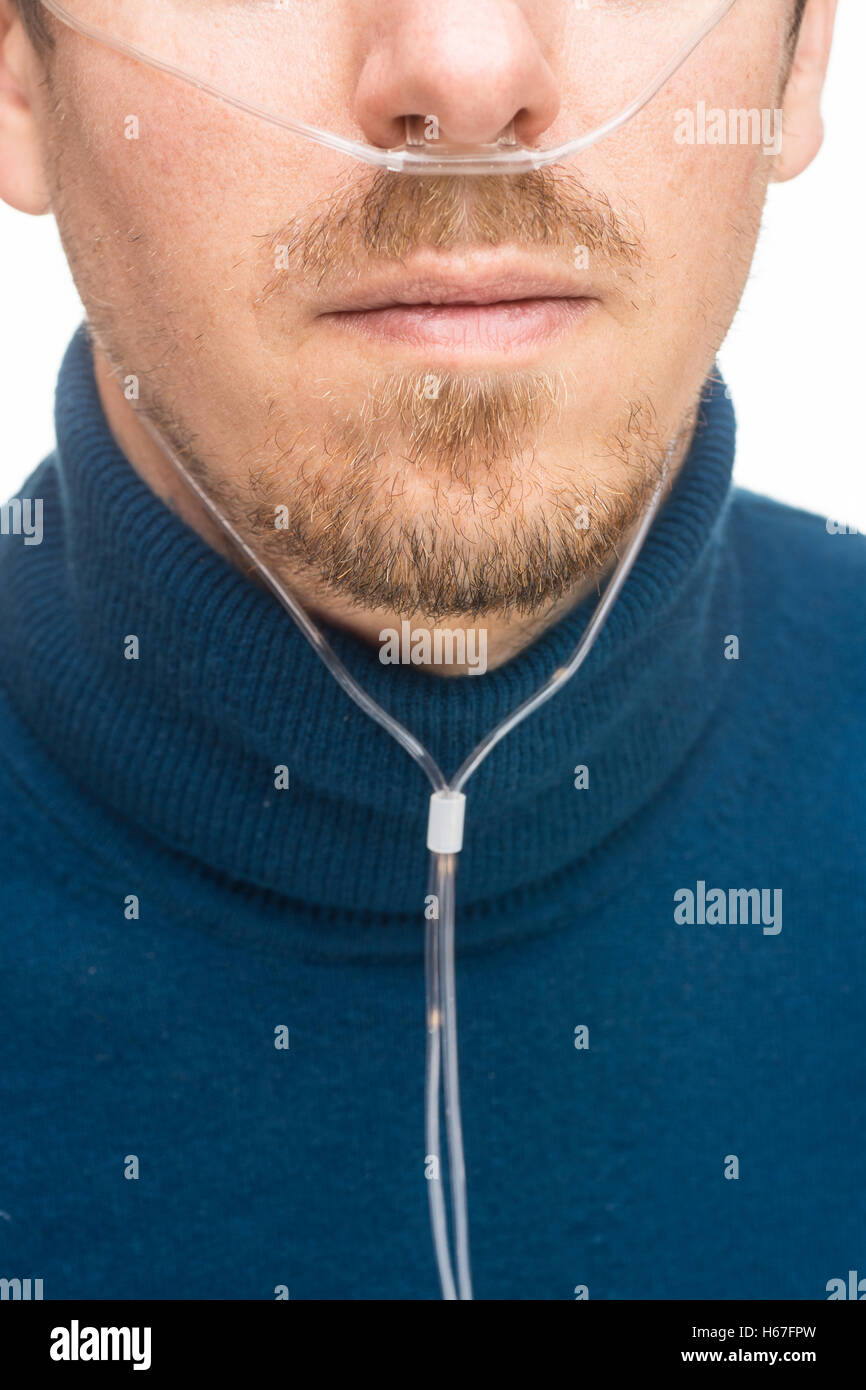 Cannula nasale per la veicolazione di ossigeno su un uomo barbuto Foto Stock