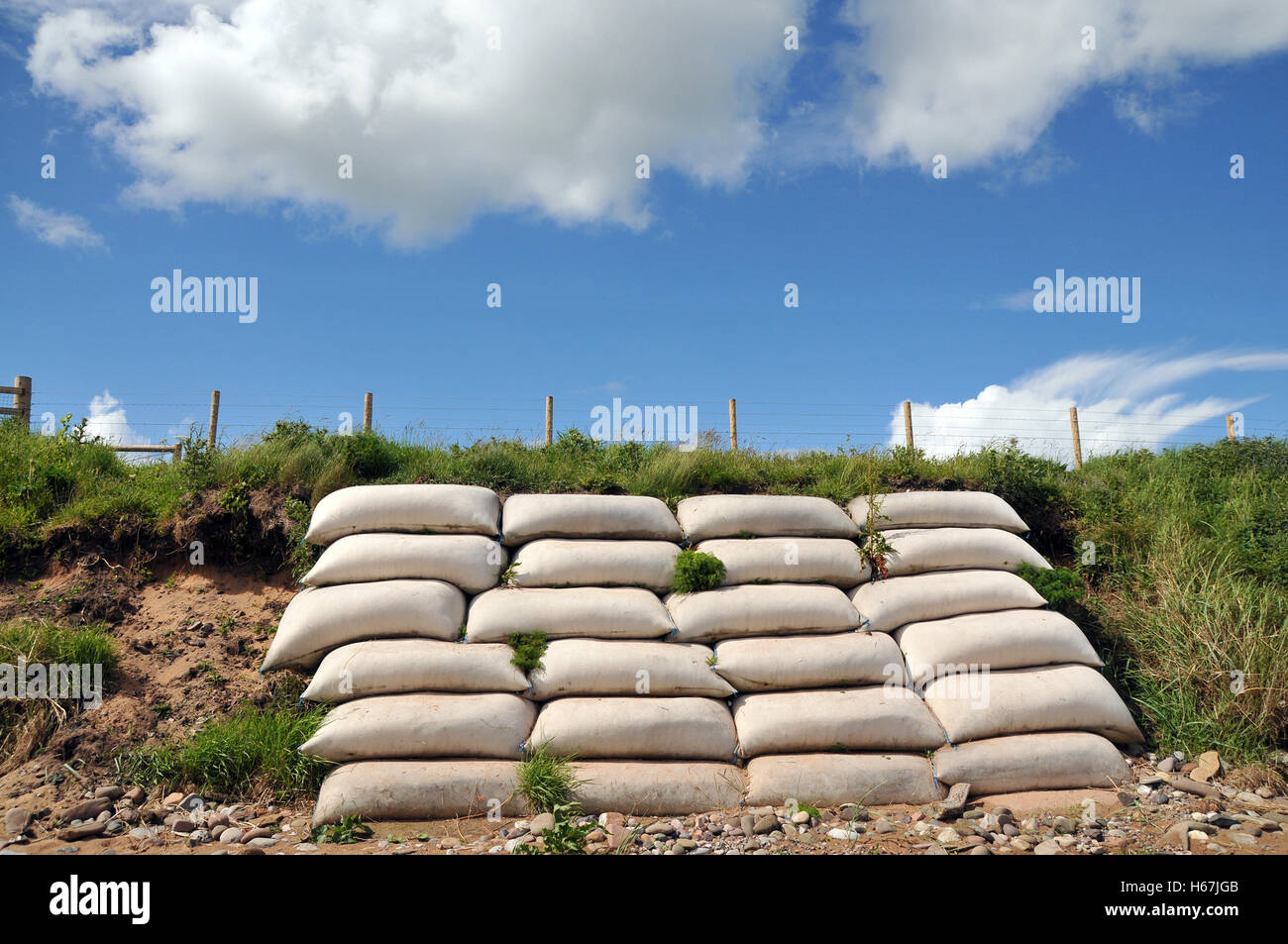 Una pila di sacchi di sabbia rivestita contro un tratto di argine costiero a rischio di erosione costiera. Foto Stock