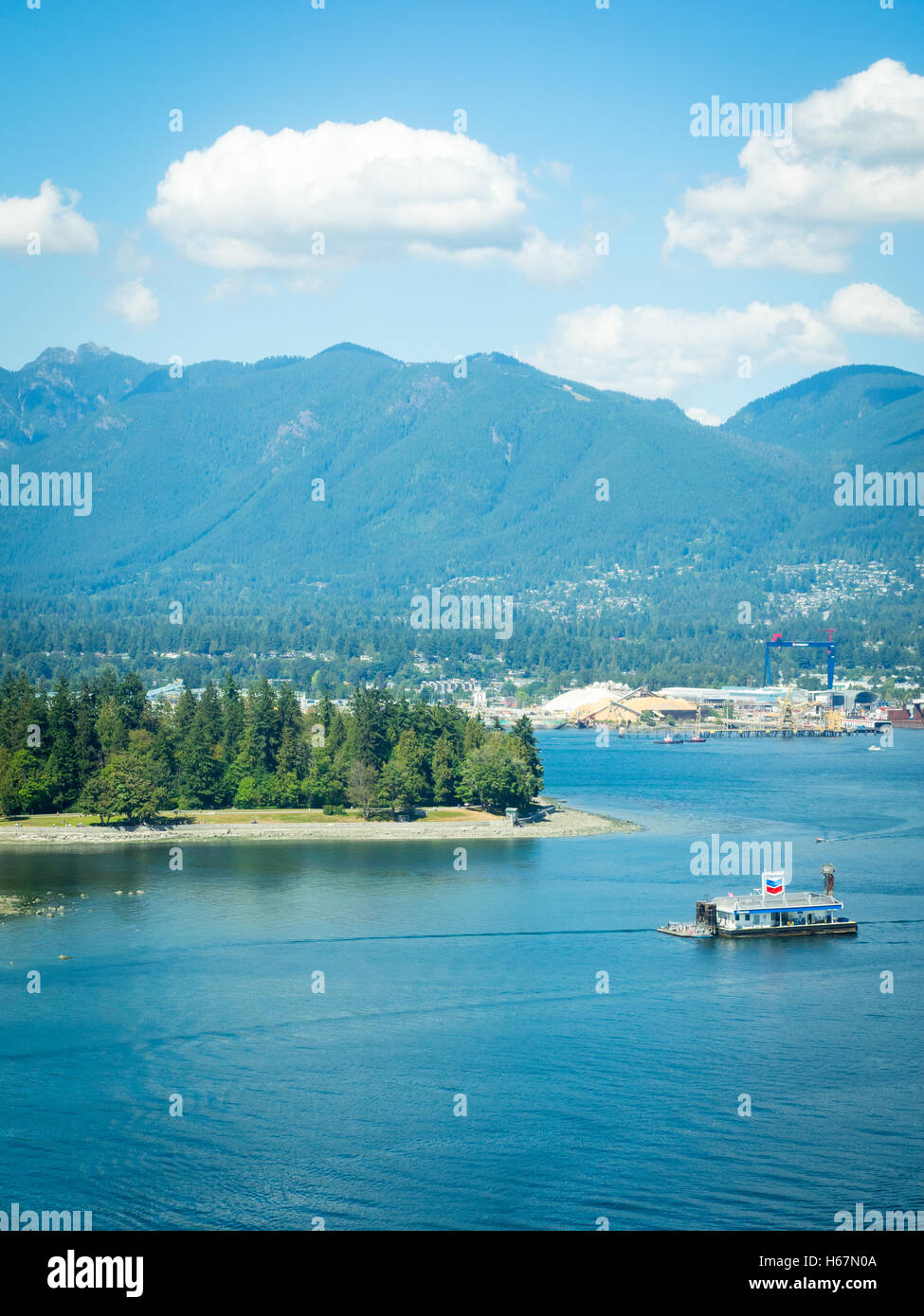 Vista in elevazione: Coal Harbour, floating Chevron la stazione di benzina, Stanley Park, il porto di Vancouver e Grouse Mountain. Vancouver. Foto Stock
