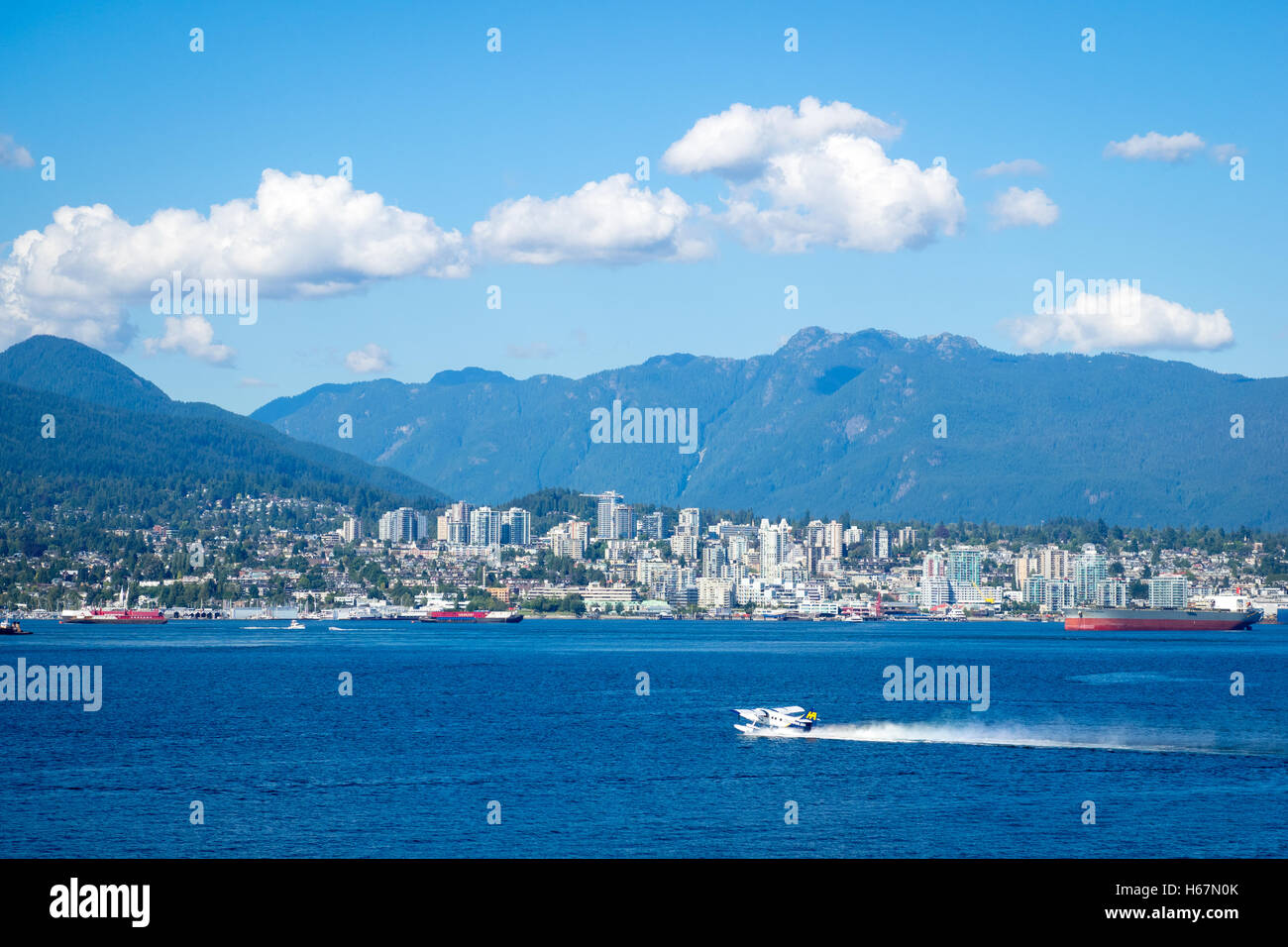 Un idrovolanti ottiene pronto al decollo nel porto di Vancouver. North Vancouver, British Columbia, Canada è in distanza. Foto Stock