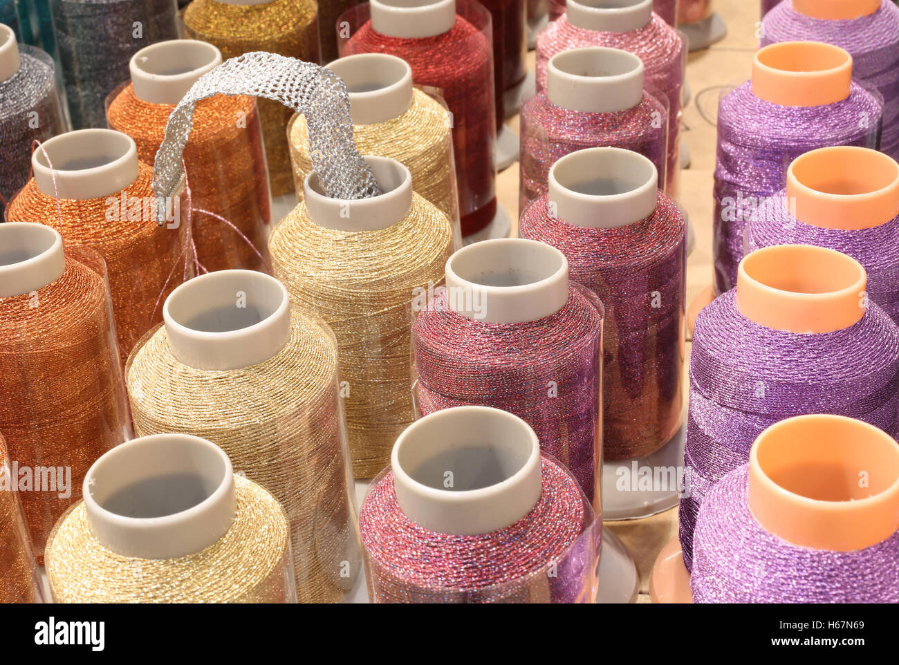 Molte colorate rocchetti di filato con strass in vendita in inglese merceria Foto Stock