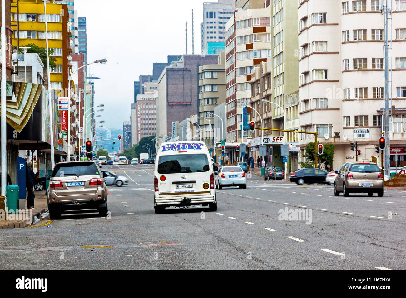 Molte persone sconosciute e dei veicoli a motore nella tranquilla nuvoloso mattino Anton Lembede Street nel centro della città Foto Stock