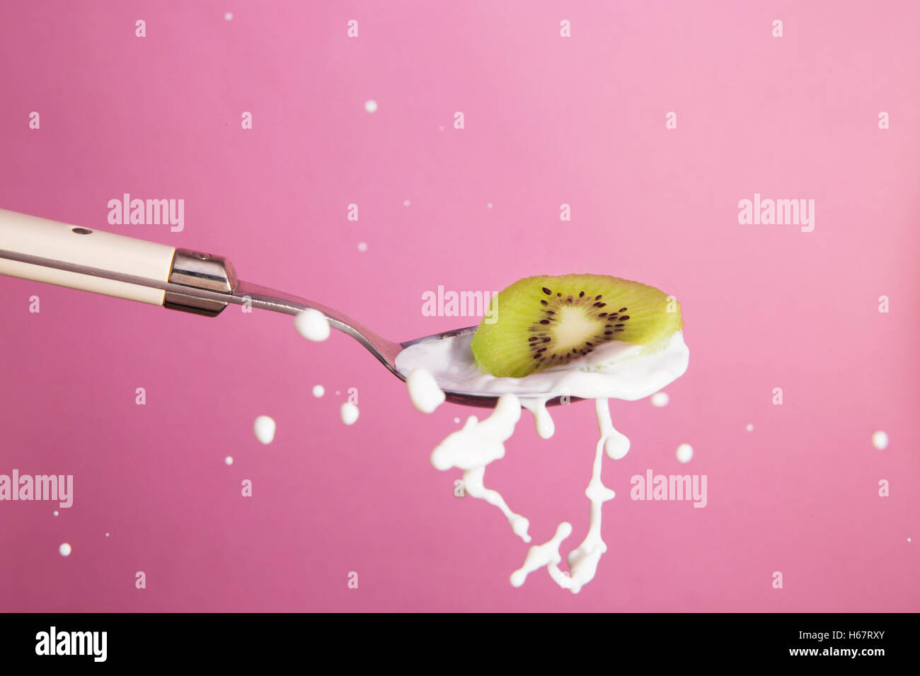 Splash ritratto del cucchiaio con kiwi e latte Foto Stock