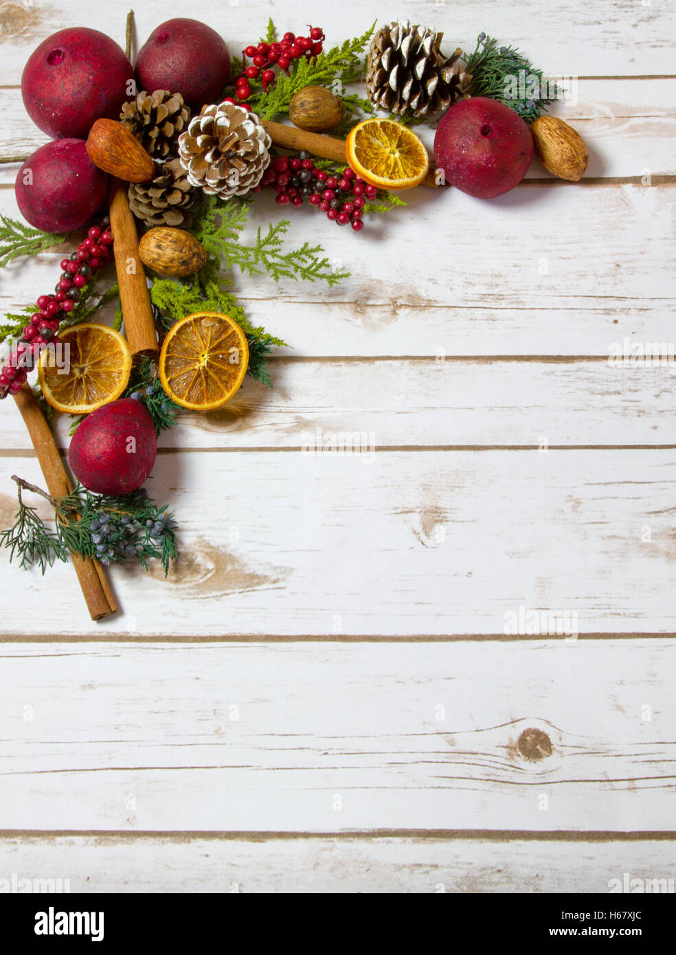 Pot-pourri di Natale sfondo con arance, frutta secca, bastoncini di cannella, i dadi con camera per copia spazio su asse di legno board Foto Stock