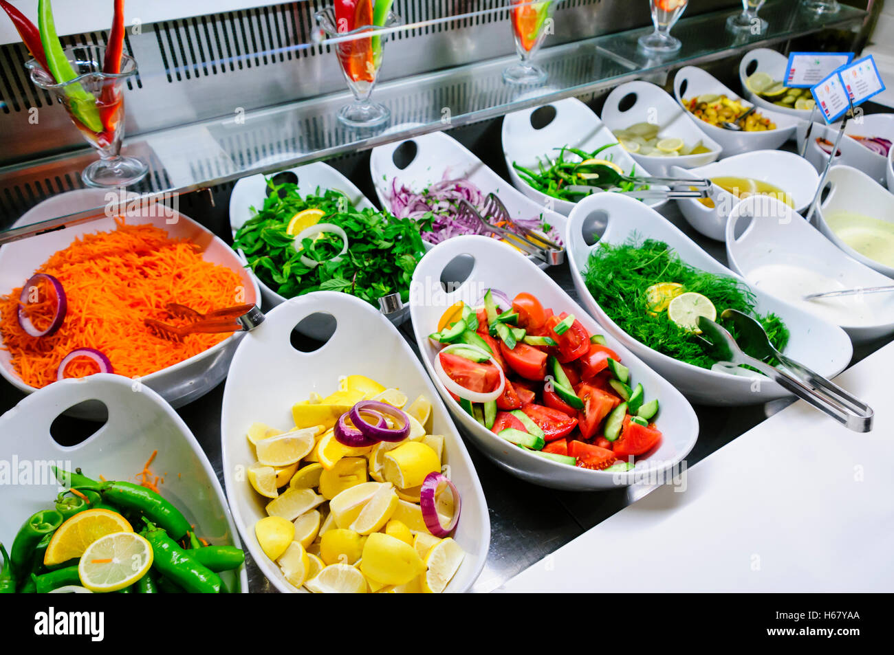 Ciotole di insalata, erbe e salse presso il buffet del ristorante dell'albergo Foto Stock