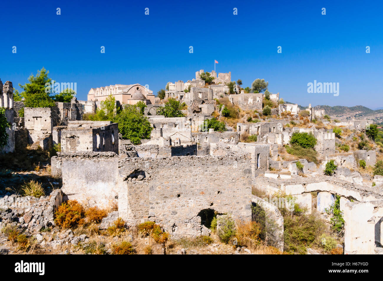 Rovine del vecchio villaggio greco di Kayakoy in Turchia, abbandonato 1922, ora un museo e conosciuta anche come la città fantasma. Foto Stock