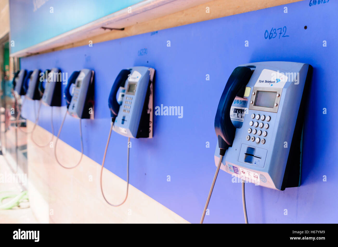 Riga blu di Turk Telecom telefoni pubblici su una parete Foto Stock