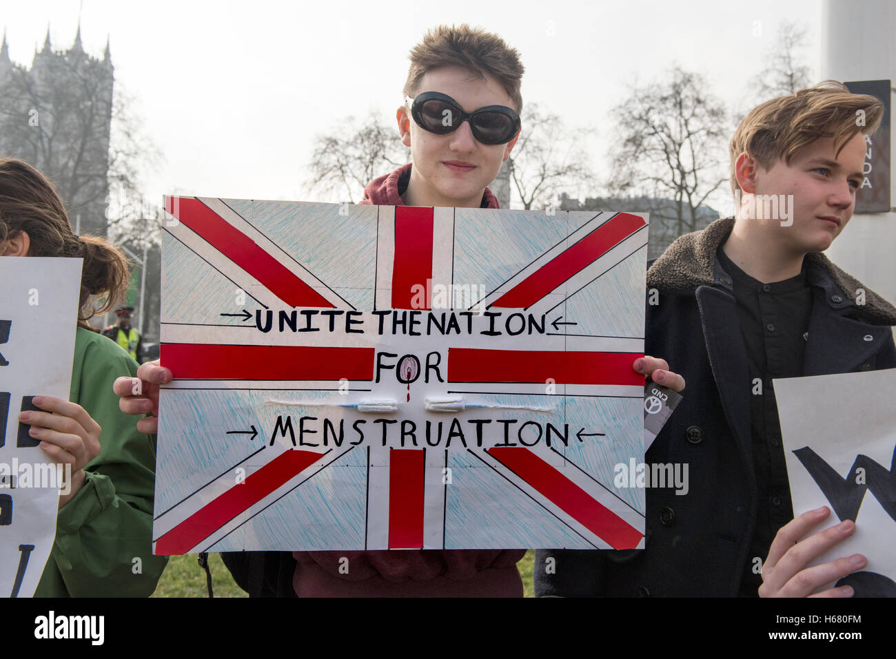 Giovane uomo è in possesso di un cartellone di lettura: "unire la nazione per le mestruazioni' durante il tampone protesta fiscale Foto Stock