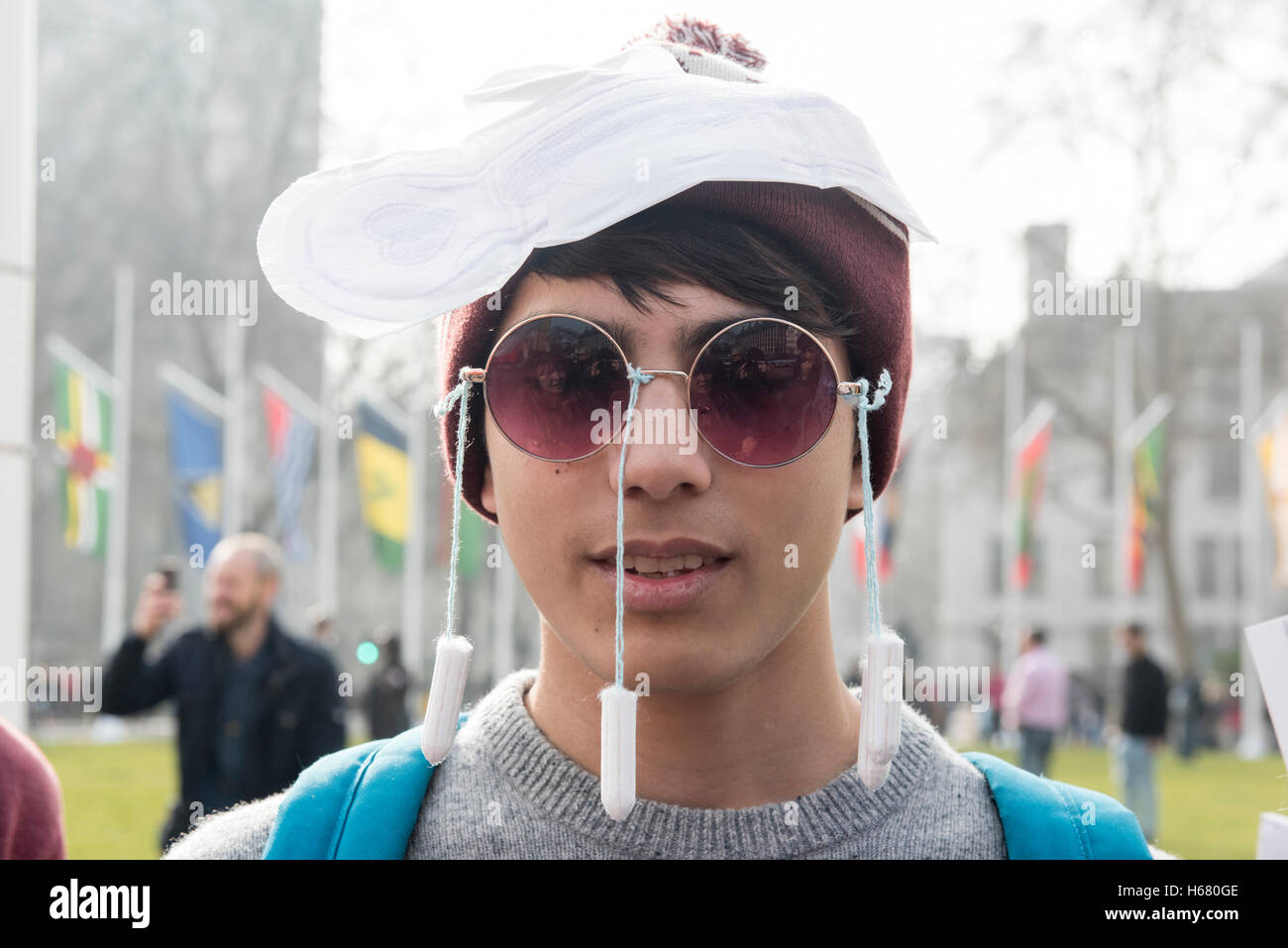 Giovane uomo che indossa i tamponi sul suo volto e un tampone igienico oltre la testa sta protestando contro la tassa di tampone Foto Stock