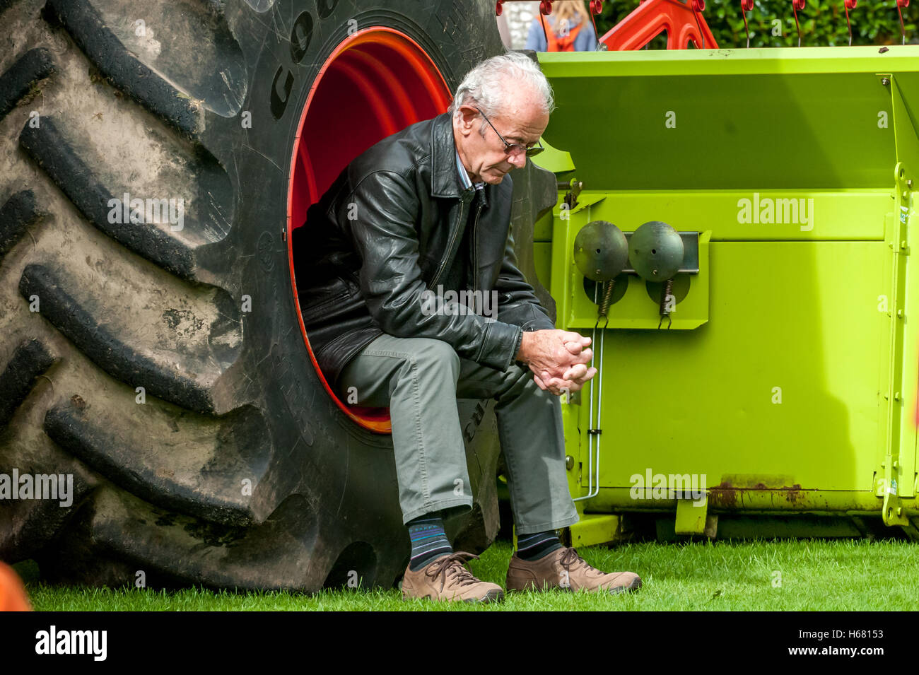 Un uomo si prende una pausa seduto al volante di una mietitrebbia Foto Stock