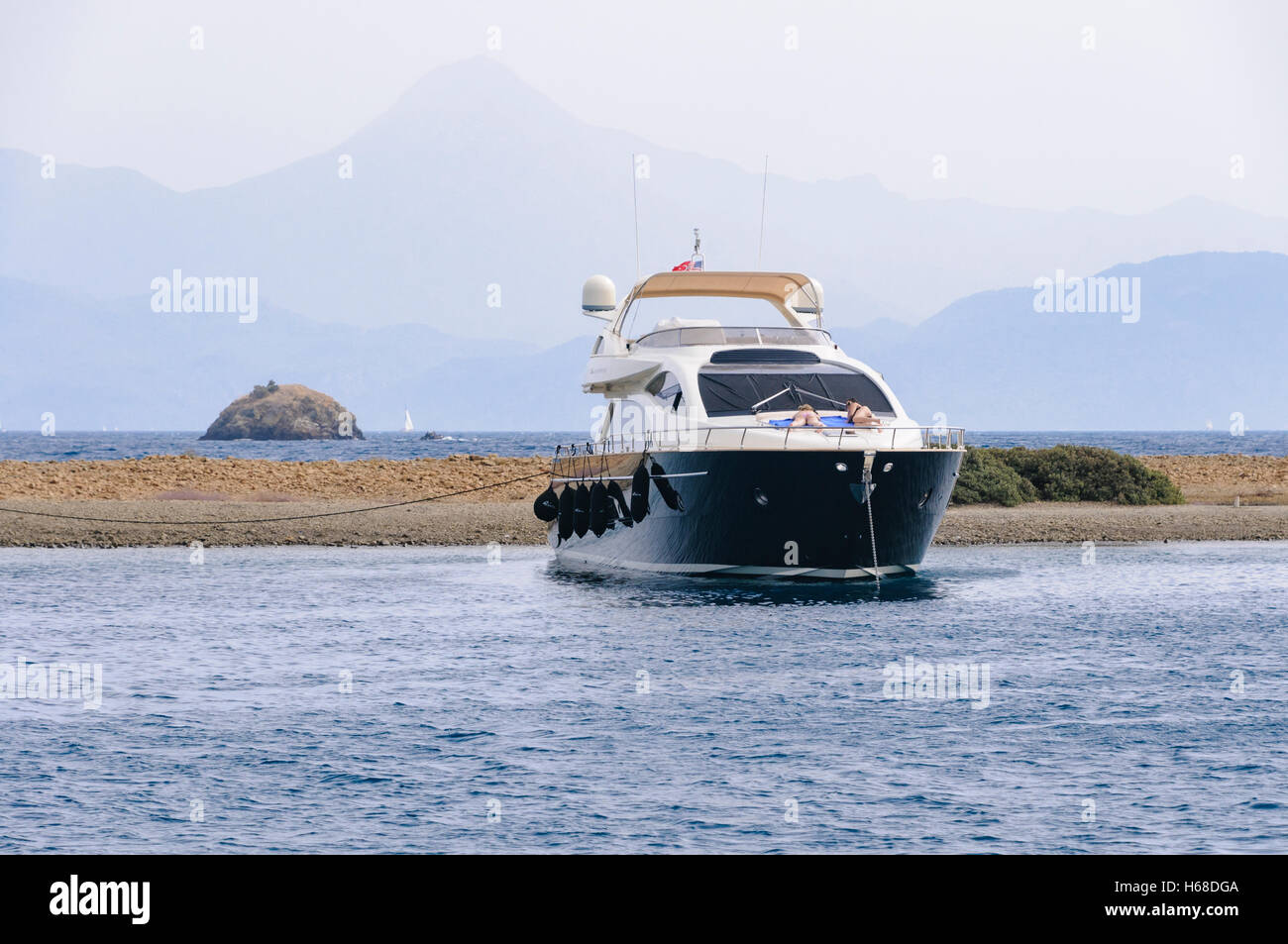 Due signore si può prendere il sole sulla prua di un incrociatore a motore come è che sono ancorate al largo della spiaggia di un isola turca. Foto Stock