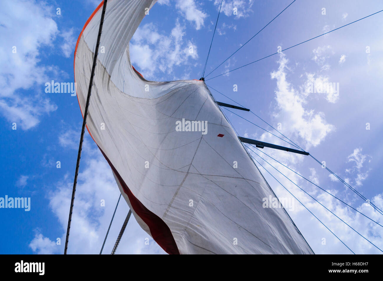 Tela Bianca di vele di una nave a vela contro un cielo blu con alcune nuvole. Foto Stock