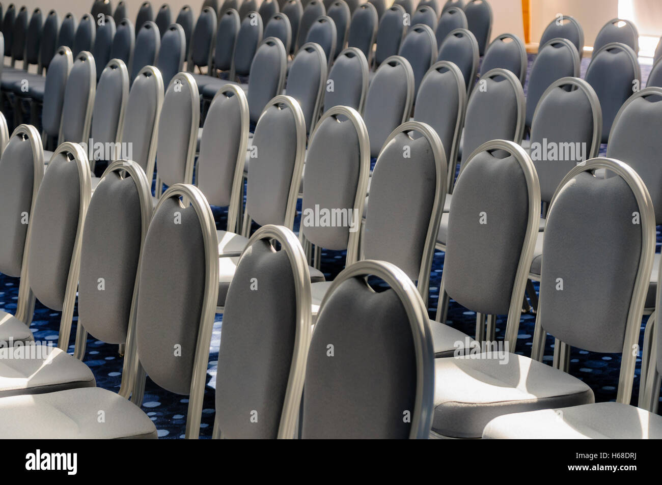 Sedie grigio schierate per una conferenza in una grande hall Foto Stock