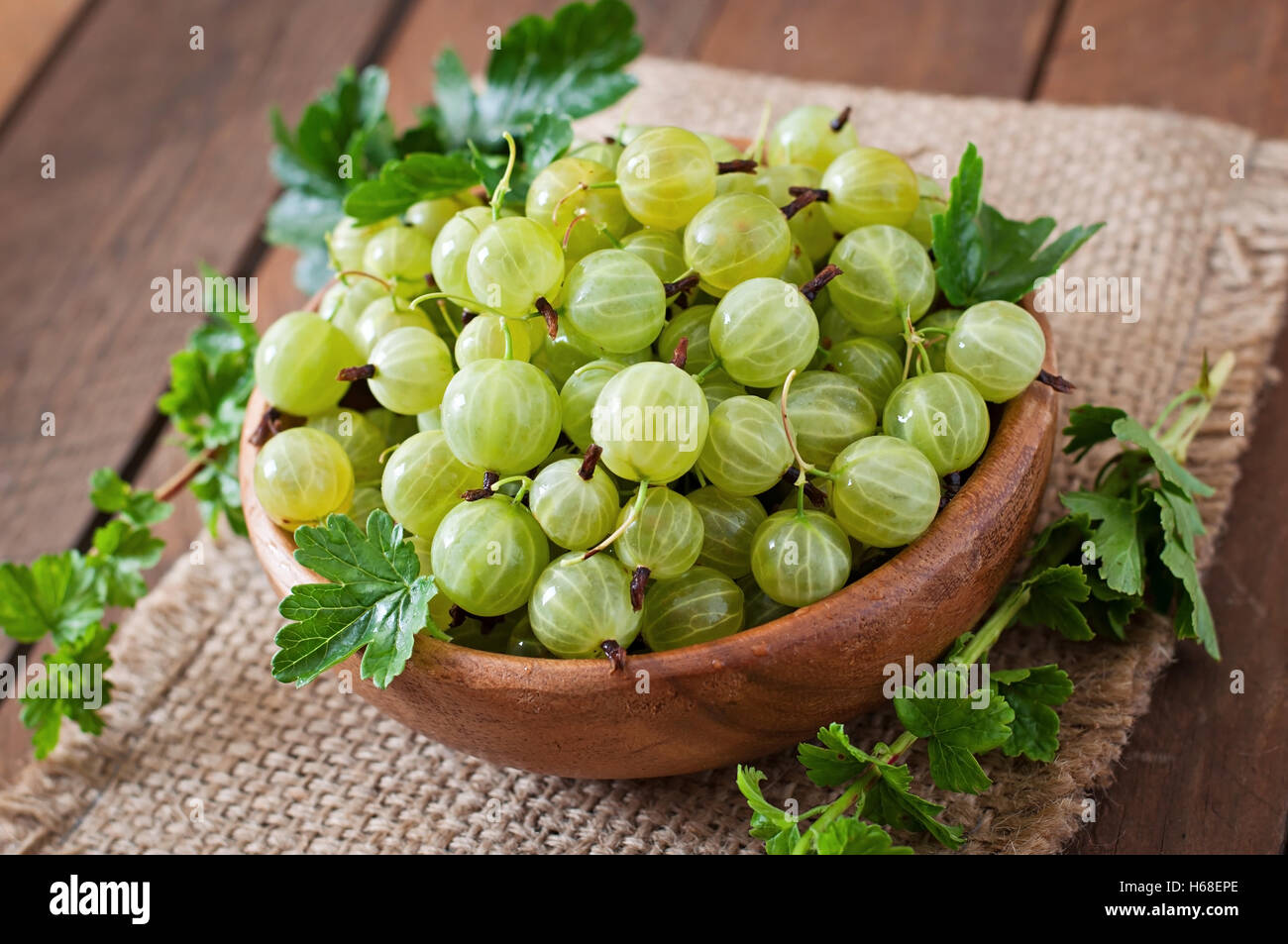 Ribes verde in una ciotola di legno Foto Stock