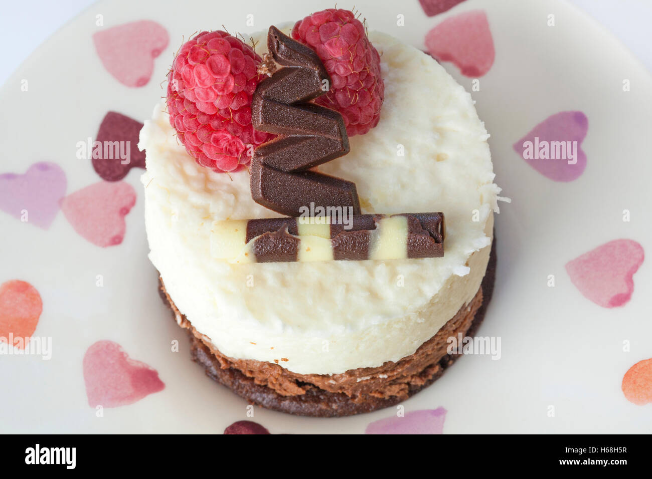 Nois Des Iles torta sul piatto decorativo con cuori sul set su sfondo bianco Foto Stock