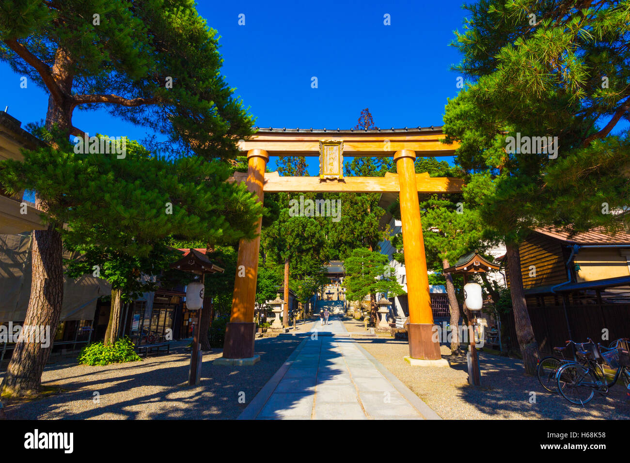 Grande porta di legno torii ingresso Sakurayama Hachiman-gu Sacrario Scintoista su un cielo blu chiaro giorno a Takayama, Giappone Foto Stock