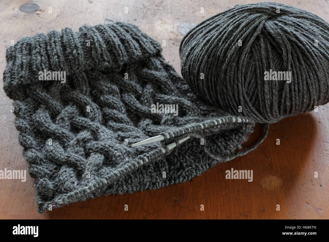 Il processo di lavorazione a maglia di un cappello con un cablaggio estensivo. Foto Stock
