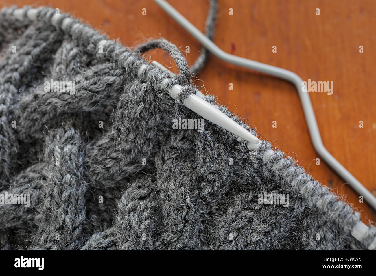 Il processo di lavorazione a maglia di un cappello con un cablaggio estensivo. Foto Stock