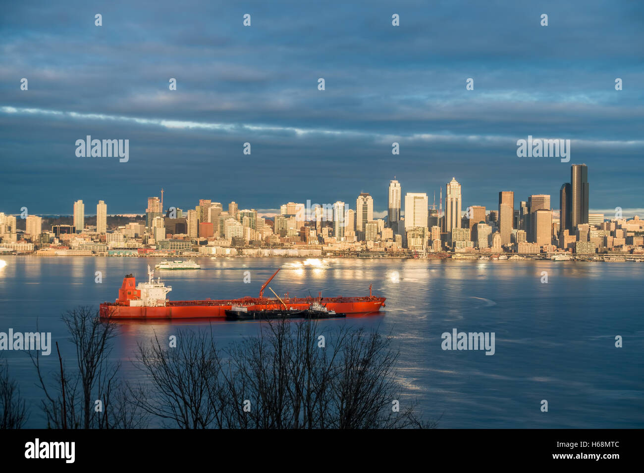 I grattacieli di Seattle riflettono il sole come una nave si sposta al di là della Baia di Elliott. Foto Stock