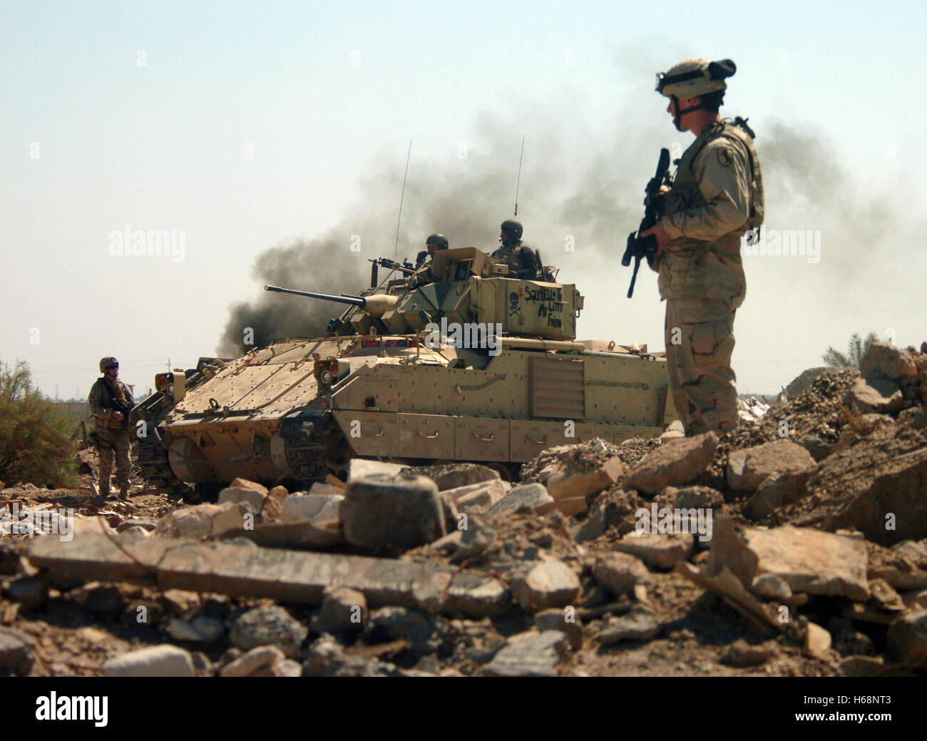 Stati Uniti I soldati dell esercito e un combattimento Bradley veicolo avanzare con cautela in un bunker area come essi conducono un raid sulle armi Hateen complesso nella Babele, Iraq. Foto Edward Martens, U.S. Navy Foto Stock