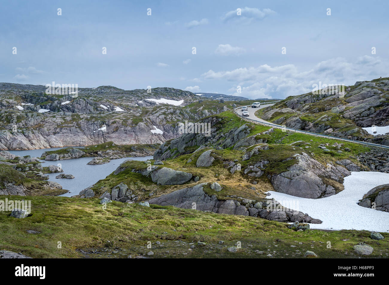 Scenic paesaggio norvegese con rocce, il lago e la curva della strada di montagna. Foto Stock