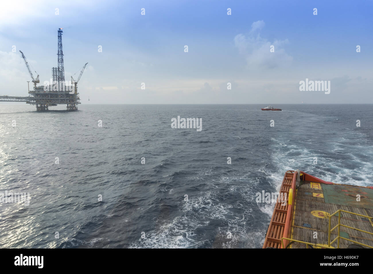 Offerta Barca a vela lontano dalla piattaforma petrolifera Foto Stock