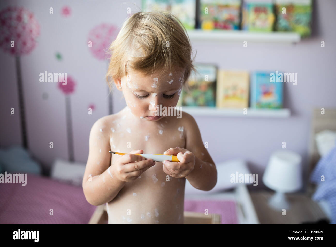 Bellissima bambina con la varicella, tenendo il termometro Foto Stock