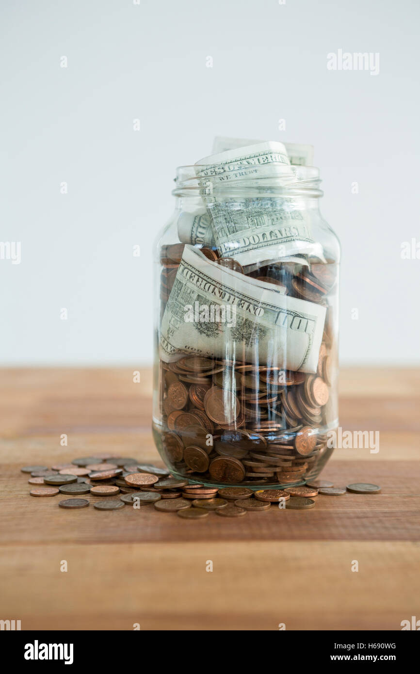 Close-up di monete e moneta note in vaso Foto Stock