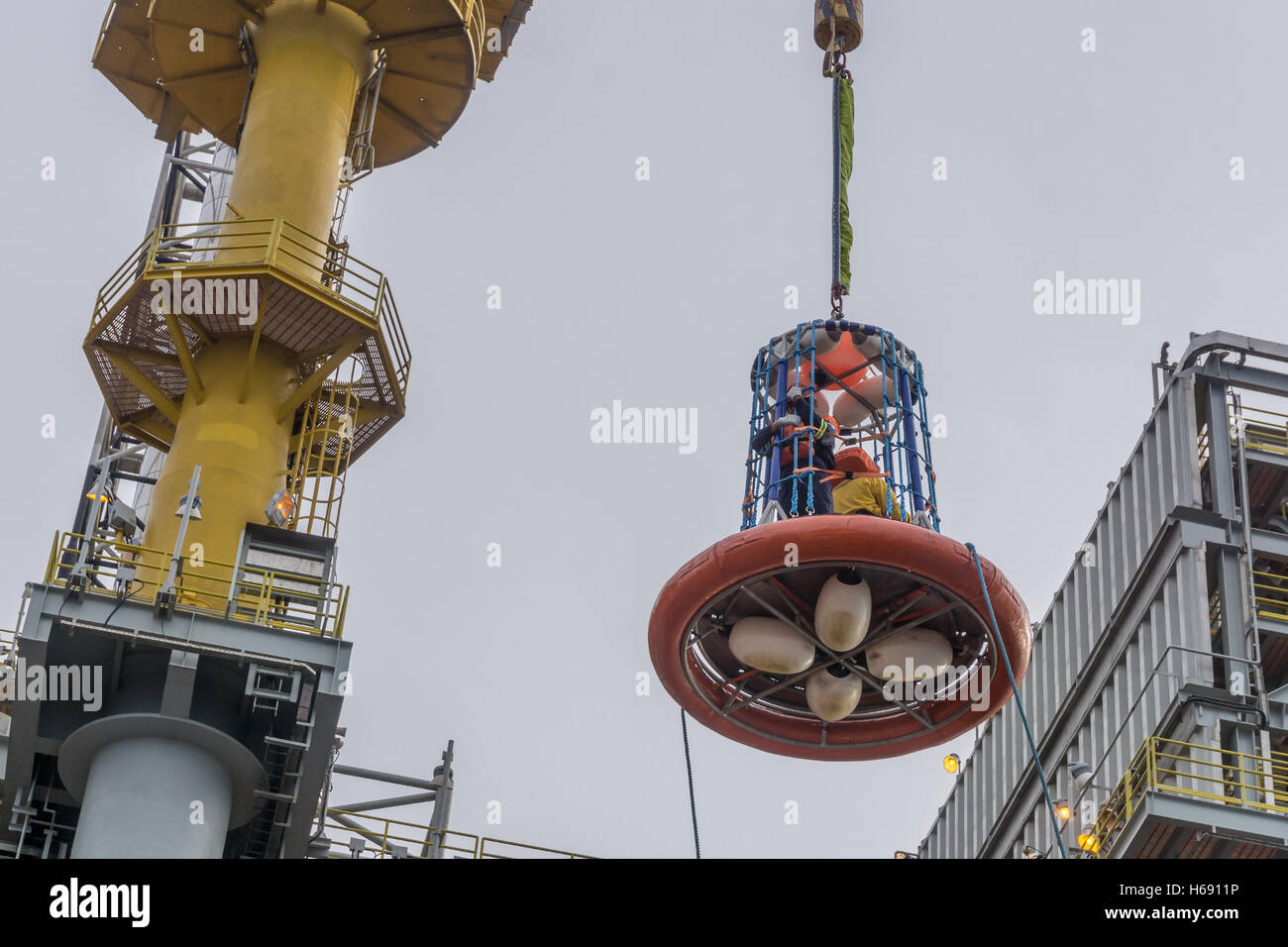 Il personale di trasferimento di cestello. Trasferire gli equipaggi offshore da rig per la barca con la gru Foto Stock