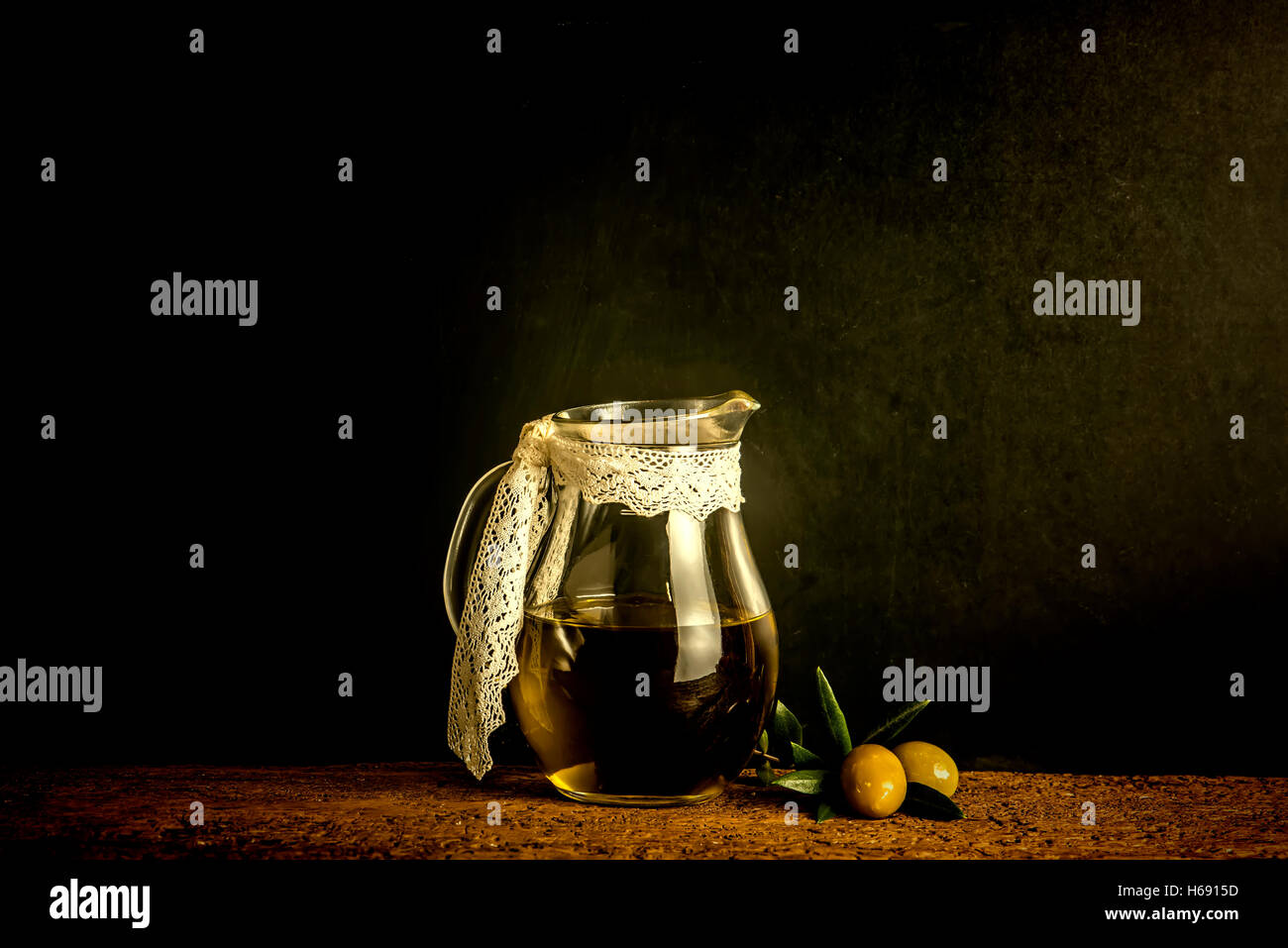 Olio extra vergine di oliva annata nel vasetto di vetro su sfondo rustico Foto Stock