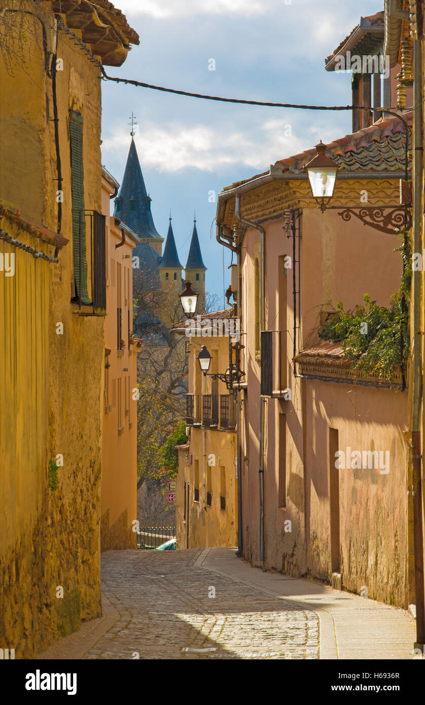 Segovia - vecchio corridoio nella luce della sera e castello Alcazar in background. Foto Stock