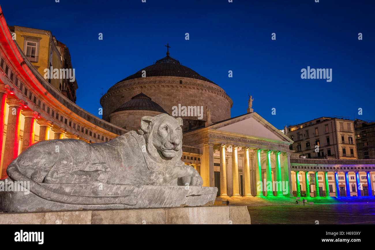 Statua di Lion e la collonade nei colori dell'arcobaleno della chiesa di San Francesco di Paola, la piazza principale di Napoli, Italia Foto Stock