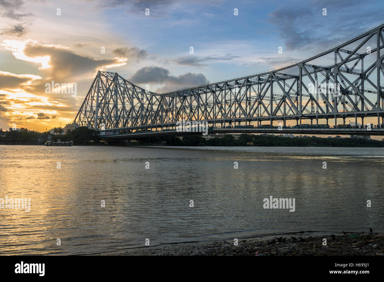 Quella di Howrah ponte sul fiume Gange (noto anche come il Fiume Hooghly) al tramonto. Fotografia scattata da Mallick ghat. Foto Stock