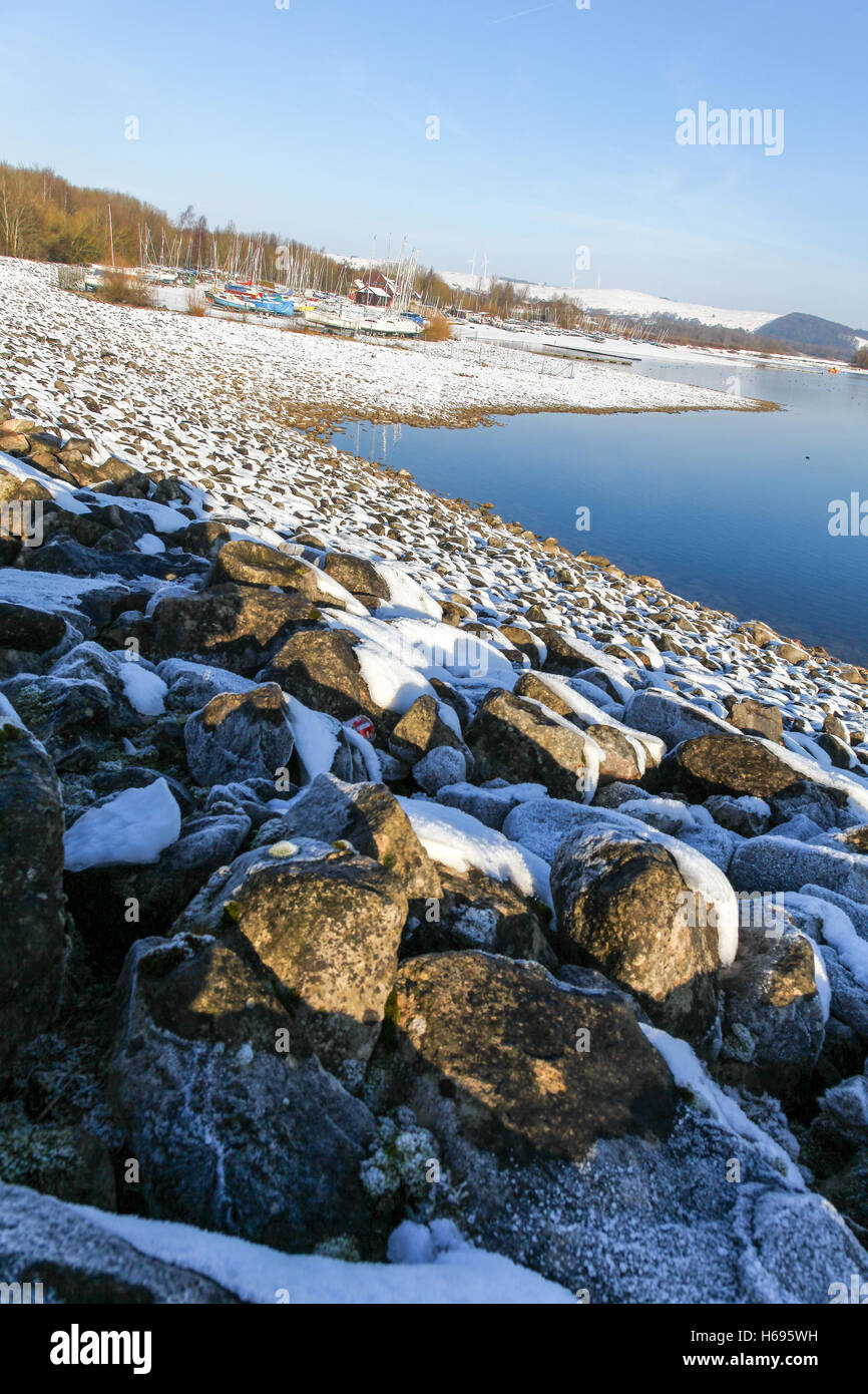 Rocce ghiacciate sulla diga a Carsington serbatoio acqua in inverno con neve sul terreno Derbyshire England Regno Unito Foto Stock