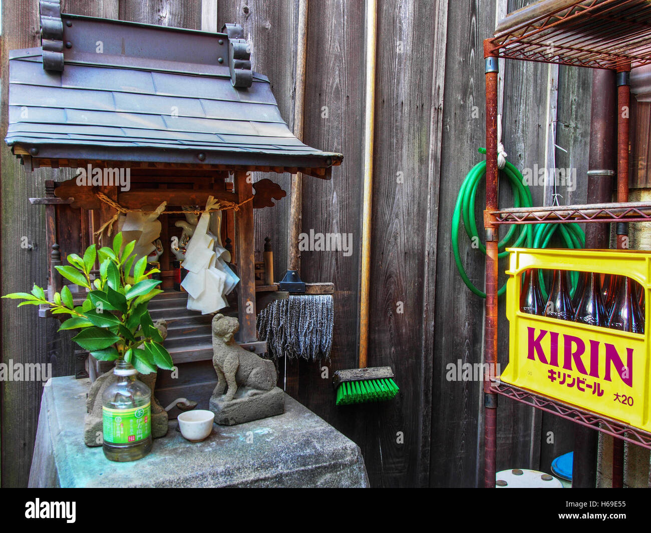 Una famiglia santuario scintoista kamidana con carta shide, kitsune statue sacre Sakaki foglie, e un sacrificio, nel cortile del ristorante, Kawagoe, Giappone Foto Stock